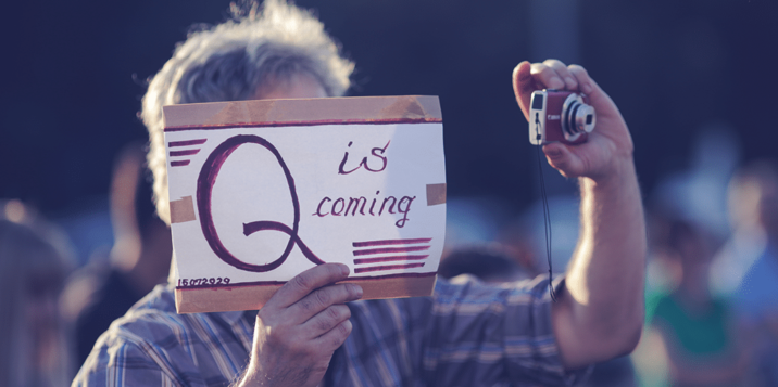 Man holding a paper Q is coming
